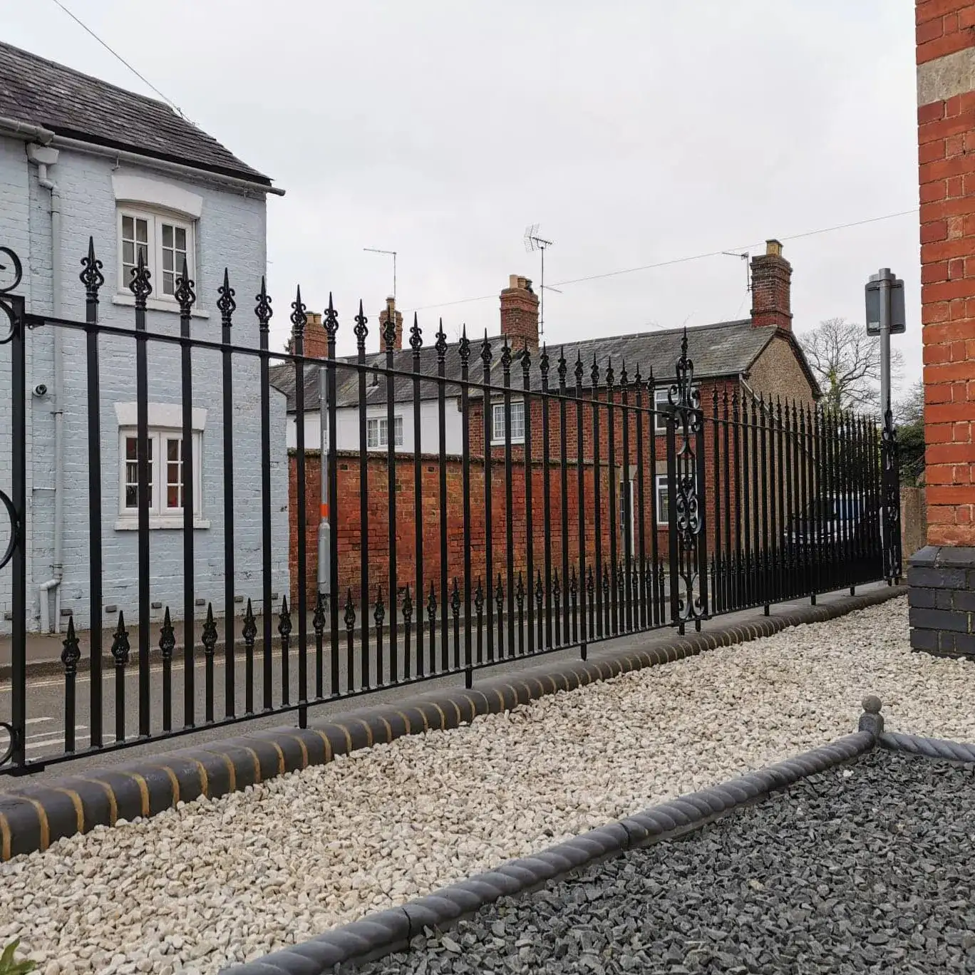 a black iron fence next to a brick building