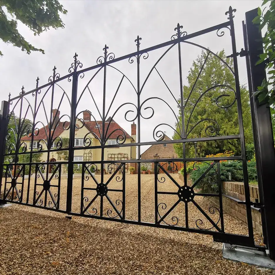a black iron fence with a house in the background